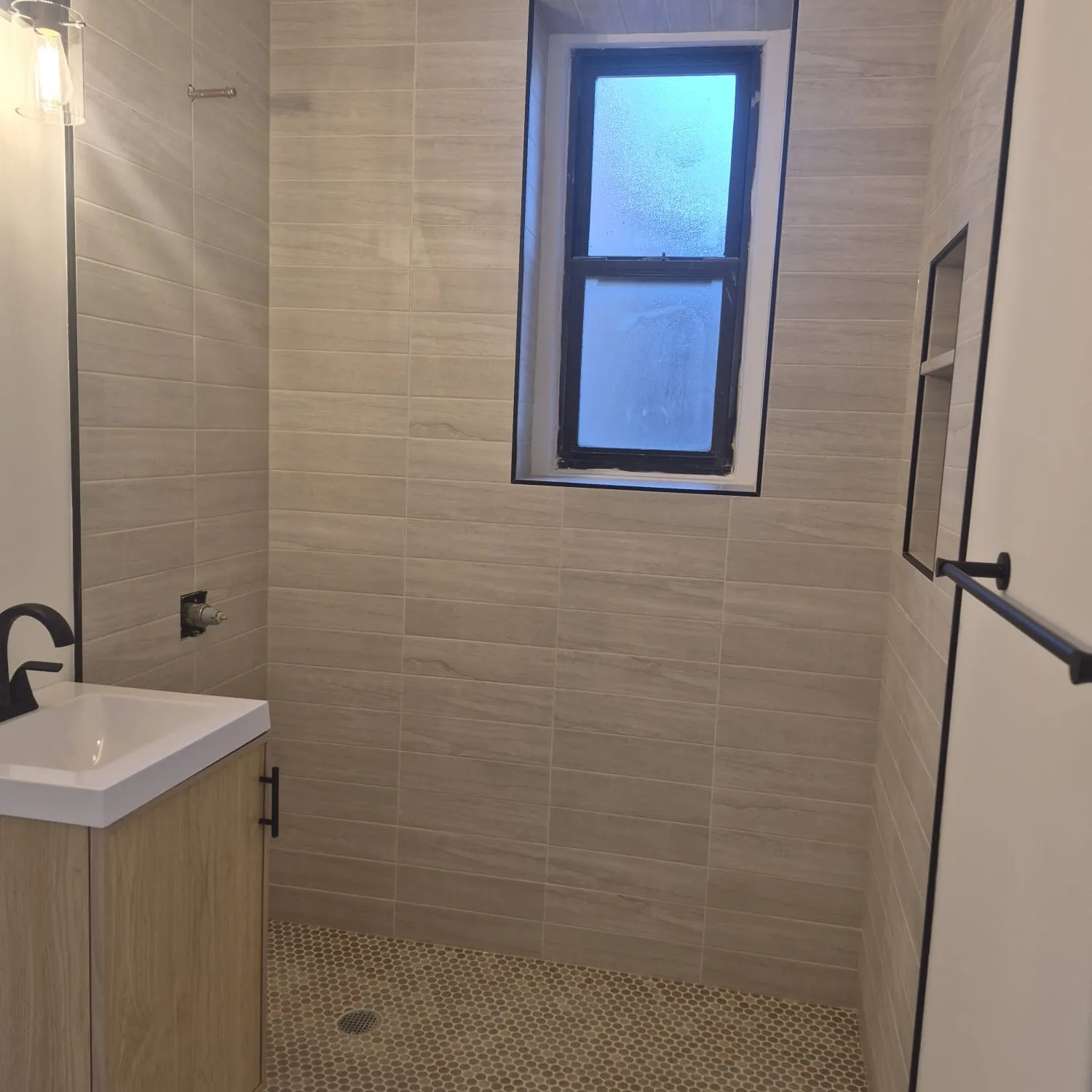 Hand-laid mosaic tile shower wall installation by LM Pro Remodeling Group