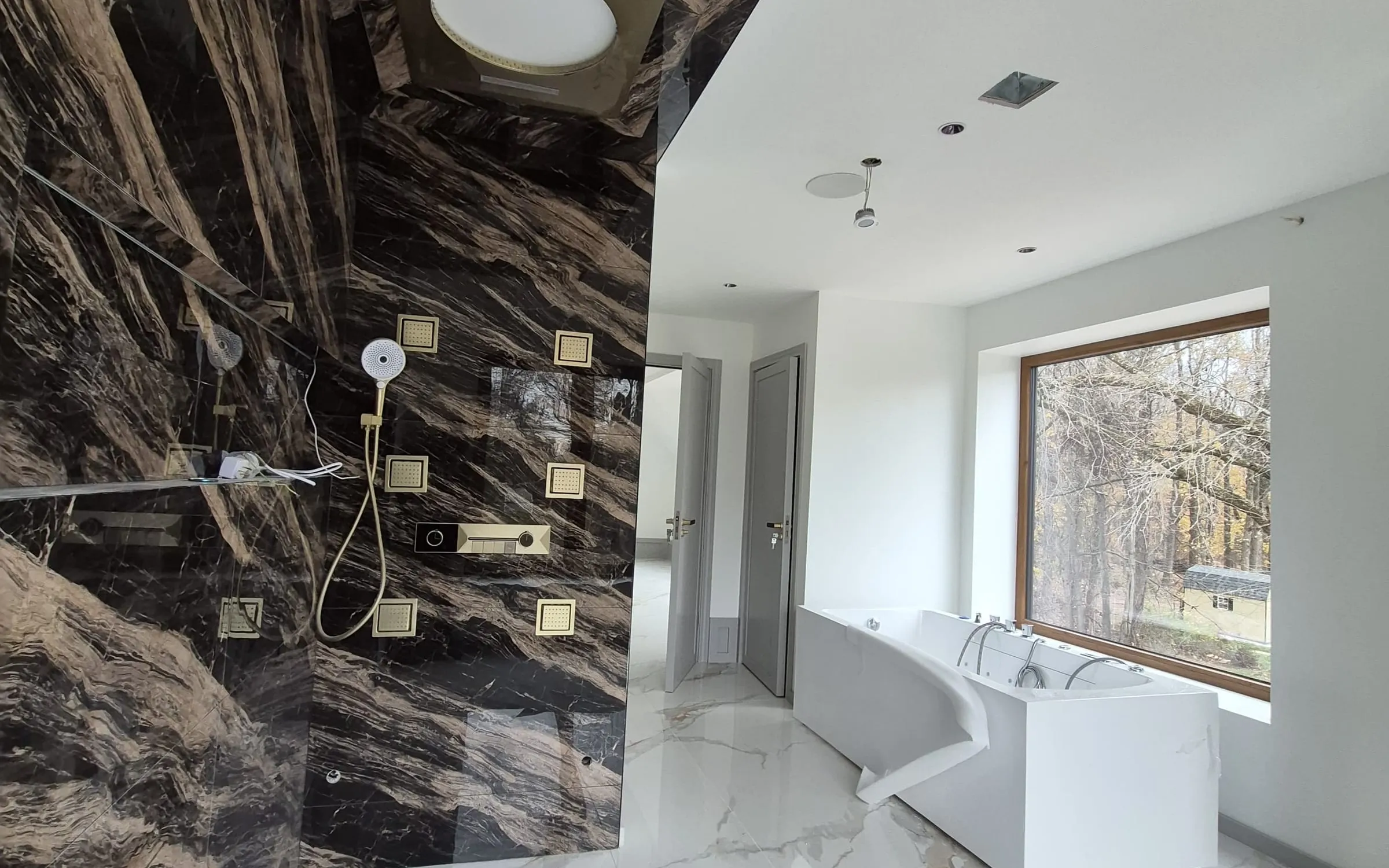 Bookmatched calacatta marble shower wall installation by LM Pro Remodeling Group