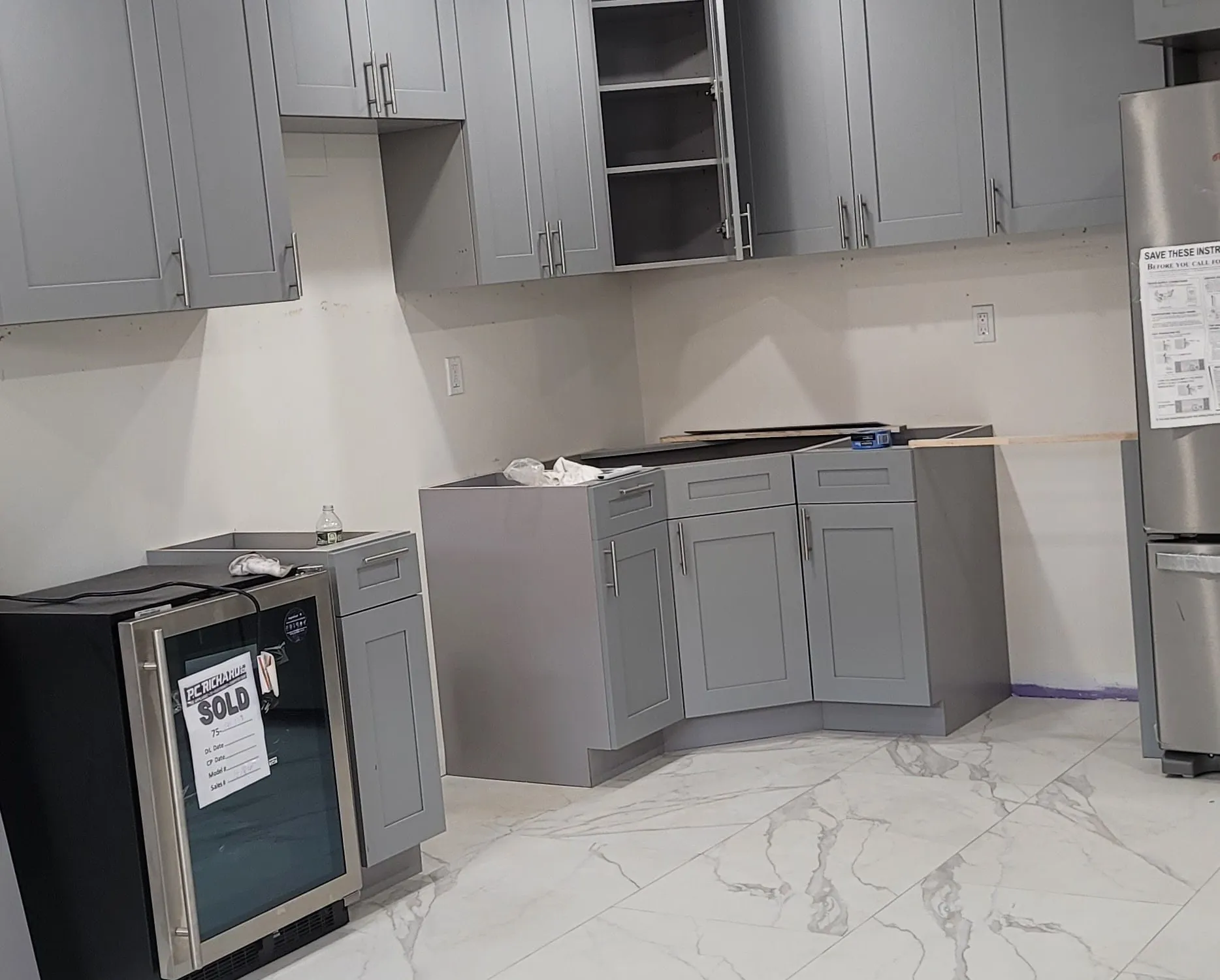 Custom kitchen remodel by LM Pro Remodeling Group, featuring rift-cut white oak cabinetry and a marble waterfall island