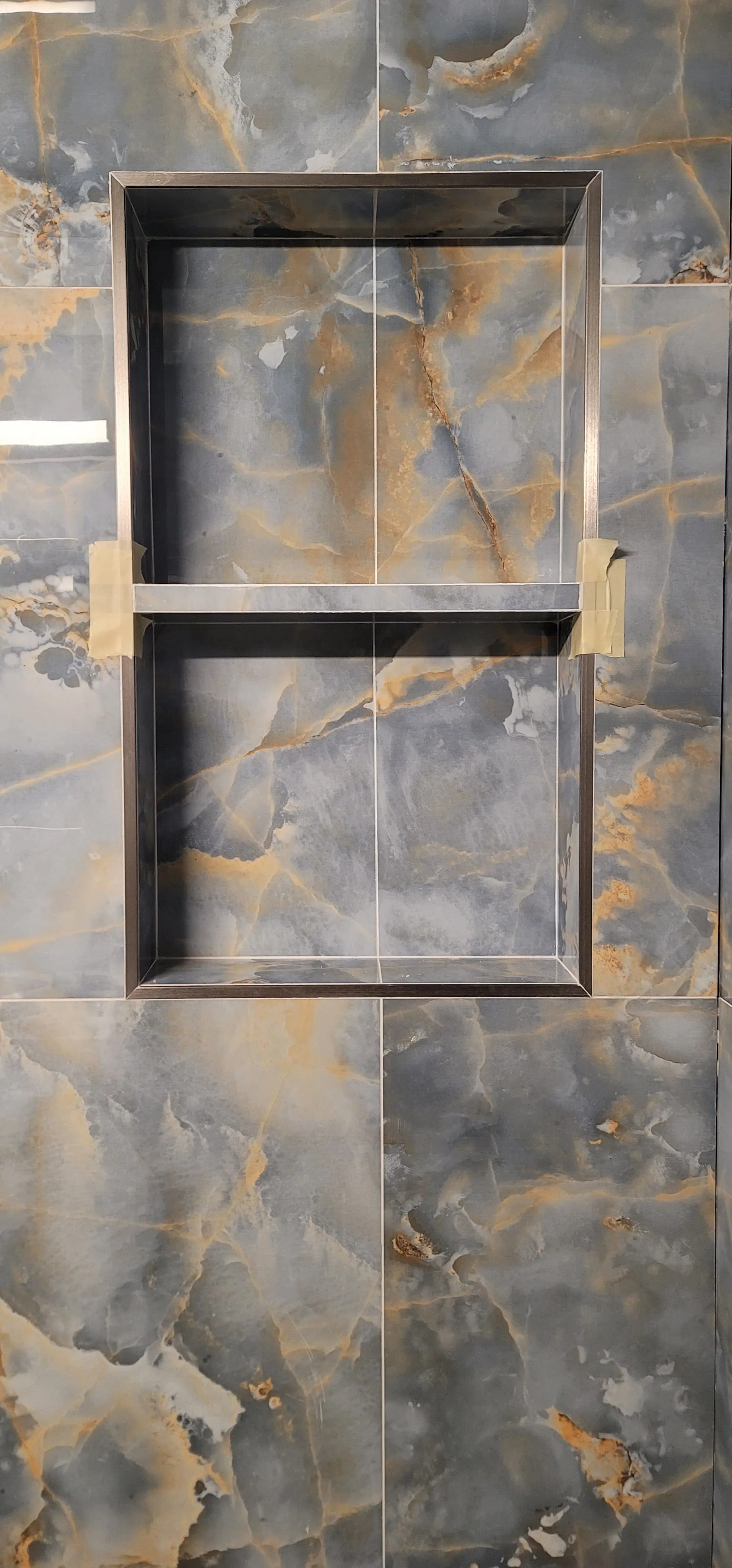 Brownstone powder room with a custom hand-laid mosaic feature wall behind a freestanding vanity — individually-set chips, hand-mitred at the cap